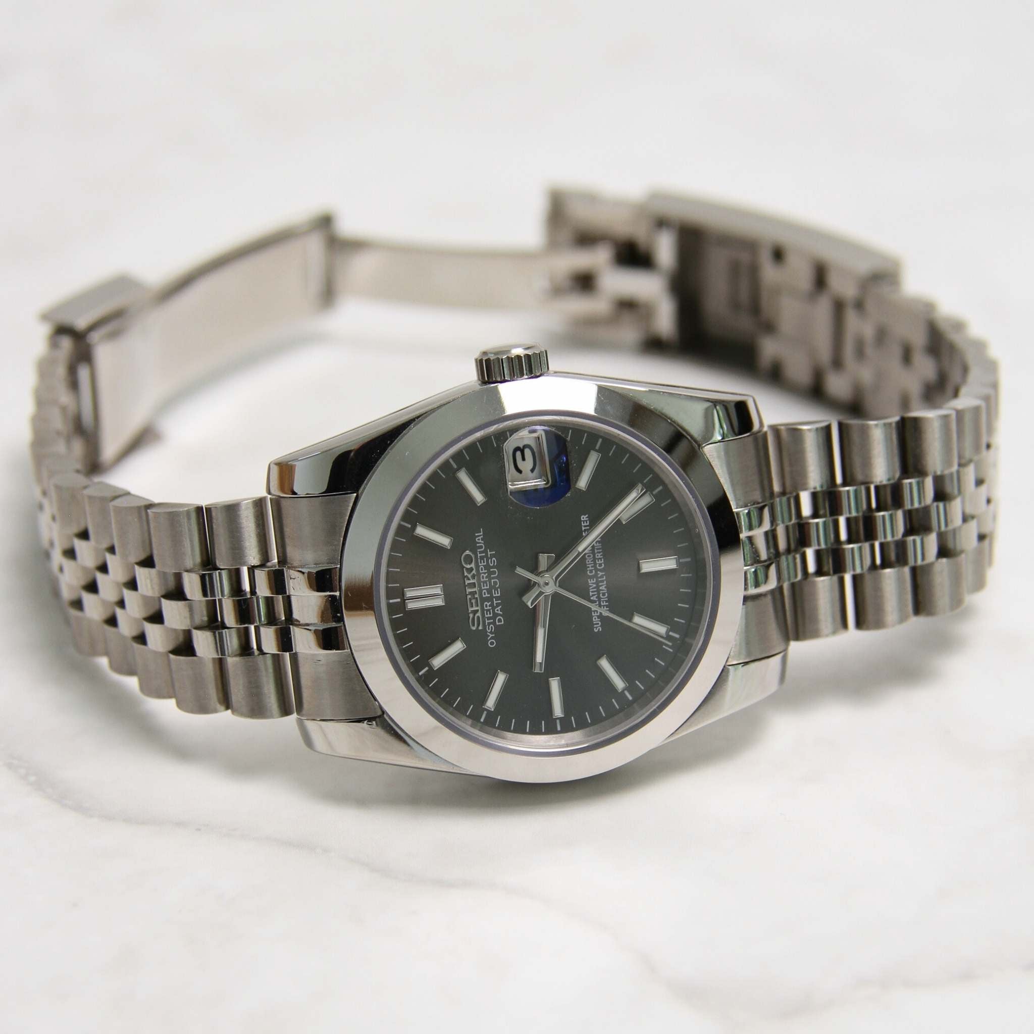 “Montre SEIKMOD Datejust Gris 36mm NH35 vue complète à plat, cadran gris et finition acier brillante”