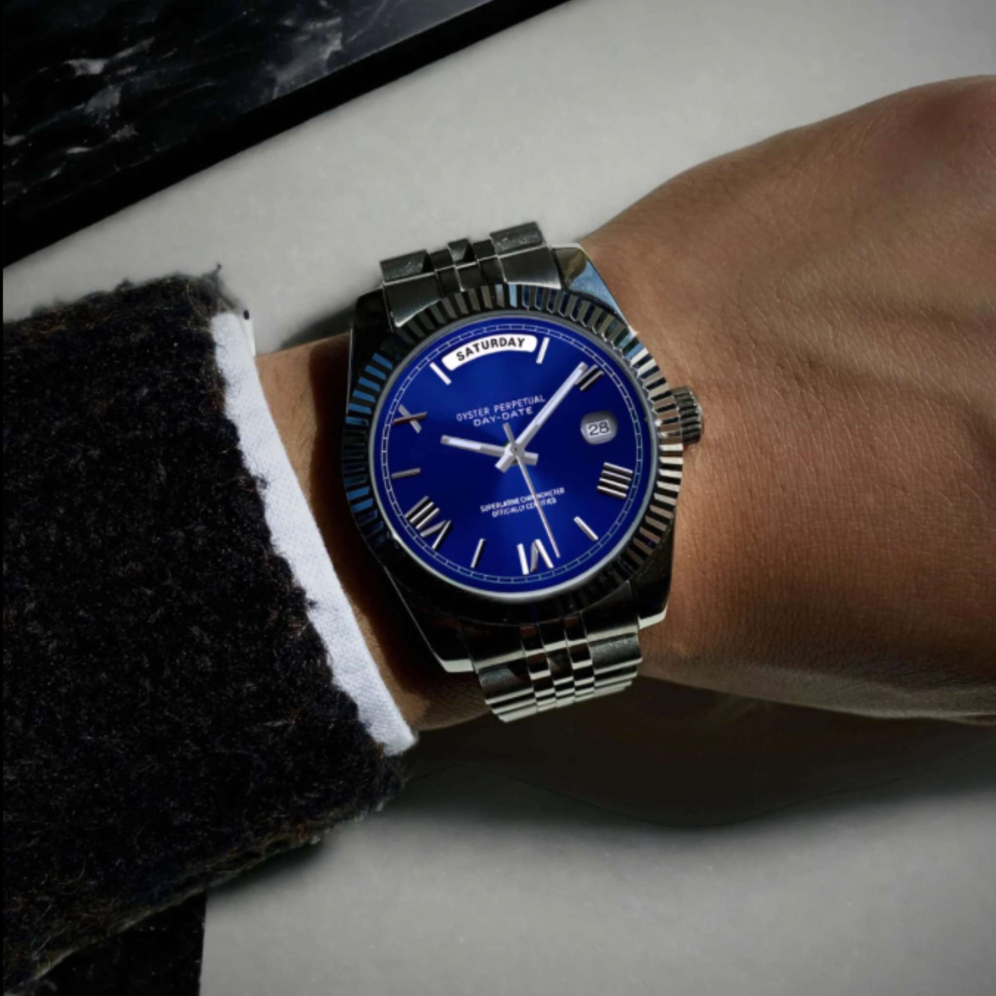 “Montre SEIKMOD Daydate Chiffres Romains Bleu Miyota 8285 portée au poignet, design raffiné et boîtier en acier inoxydable 316L”