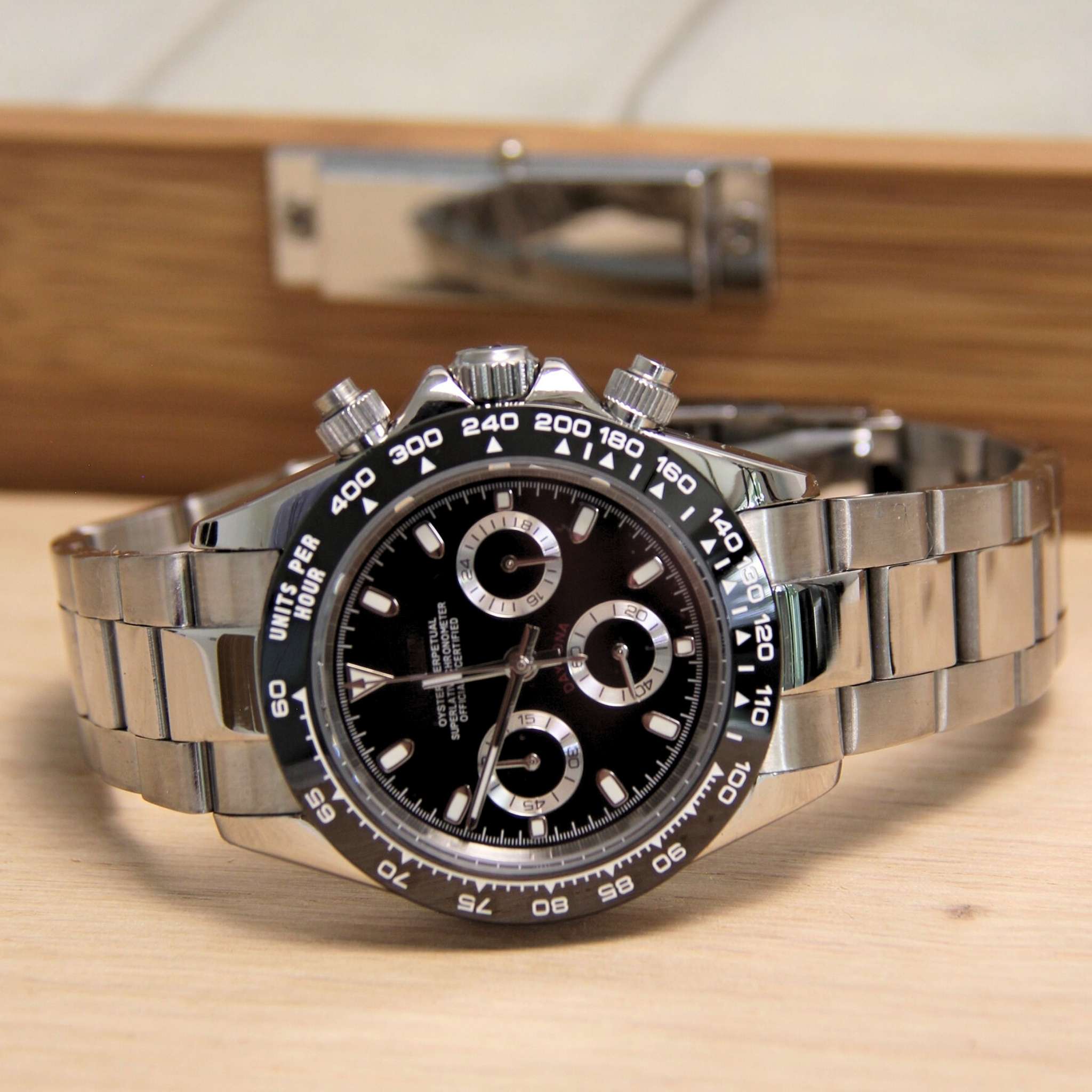 “Montre SEIKMOD Daytona Noir VK63 vue complète à plat, cadran noir et lunette tachymétrique en acier poli”