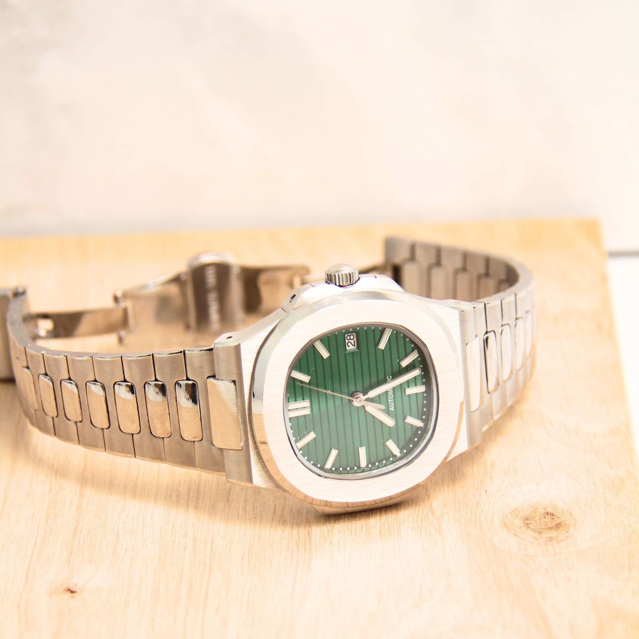 “Montre SEIKMOD Nautilus Vert NH35 vue complète à plat, cadran vert émeraude et bracelet acier intégré”