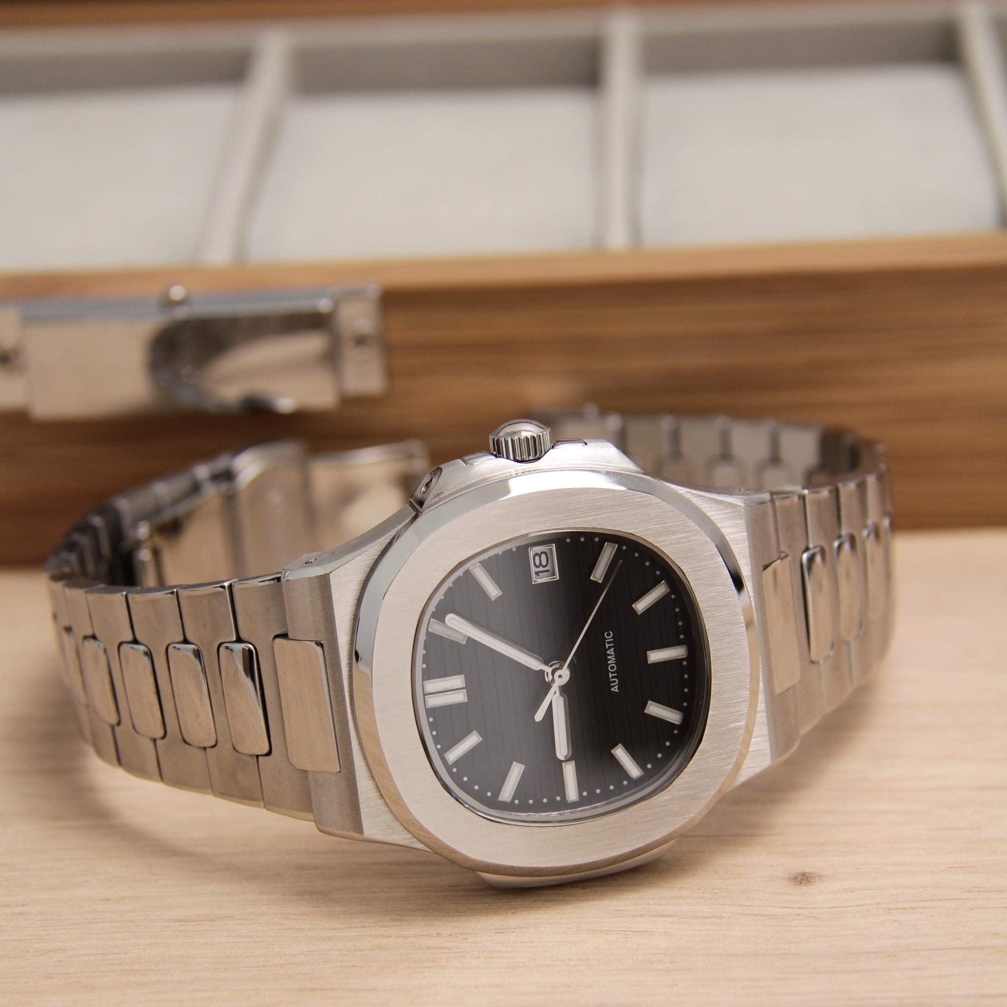 “Montre SEIKMOD Nautilus Noir NH35 vue complète à plat, cadran noir et bracelet acier intégré poli et brossé”